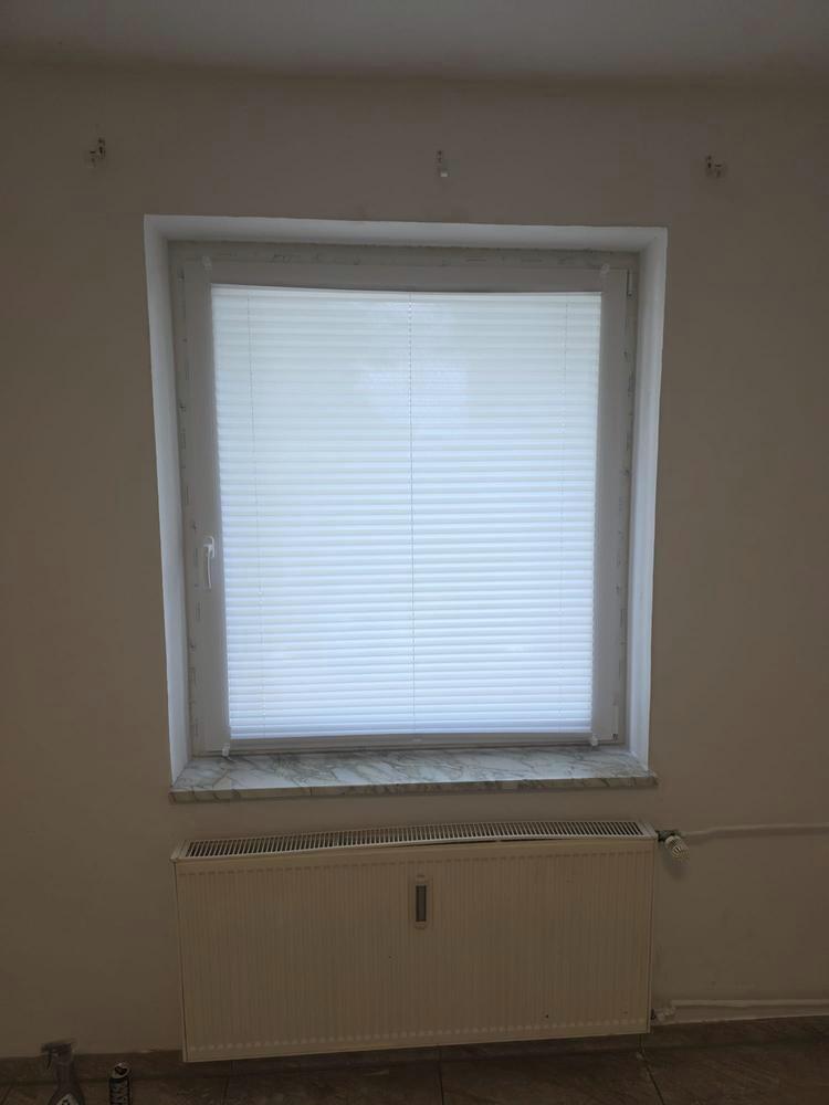 Fenster mit weißem Plissee als Blendschutz