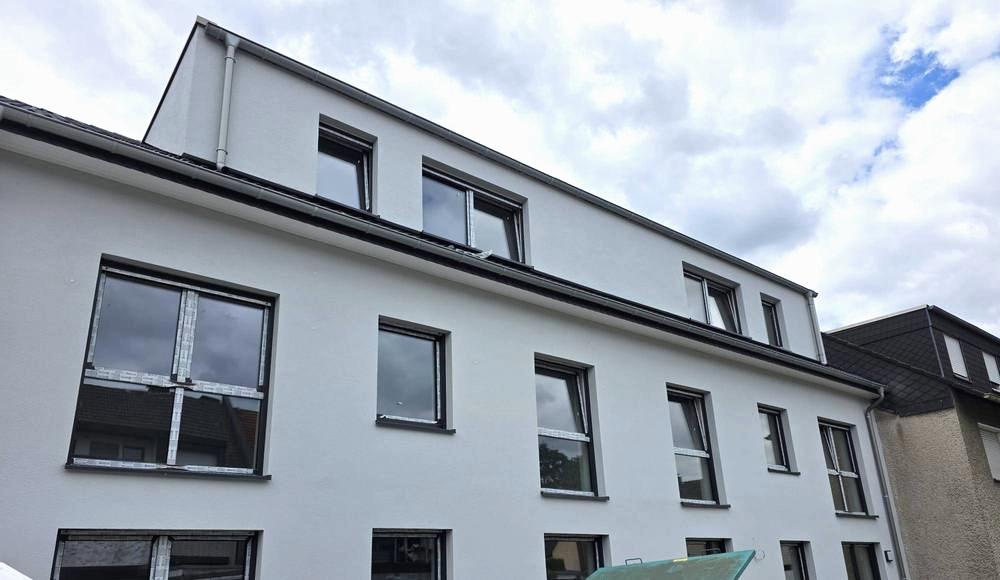 Fassade eines Mehrfamilienhauses mit neu eingebauten Fenstern