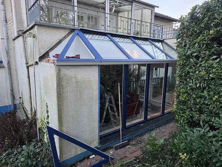 Neue Verglasung mit blauen Profilen an einem Anbau