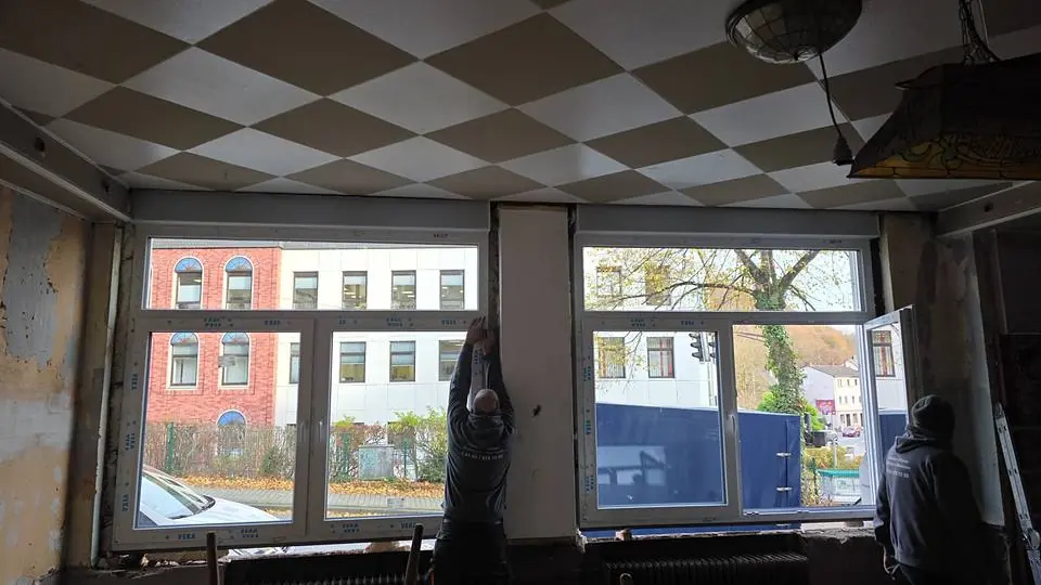 Monteure setzen neue Fenster in einem Gastraum ein