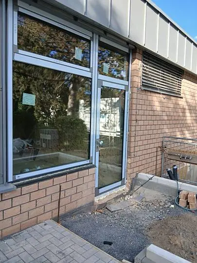 Neue Aluminium-Fenster und Tür an einer Klinkerfassade